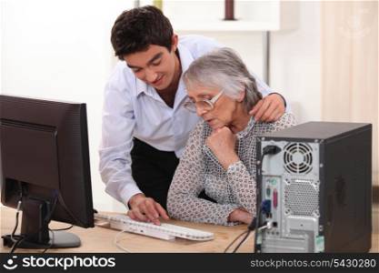 Young man showing grandmother computer