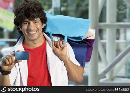 Young man showing his credit card for easy shopping