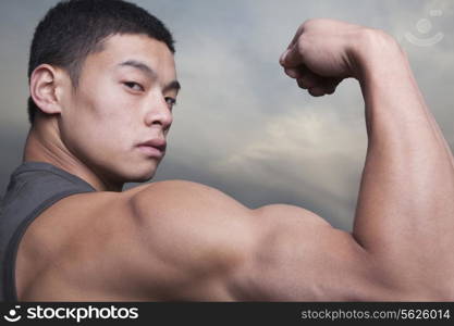 Young Man showing off his bicep muscles