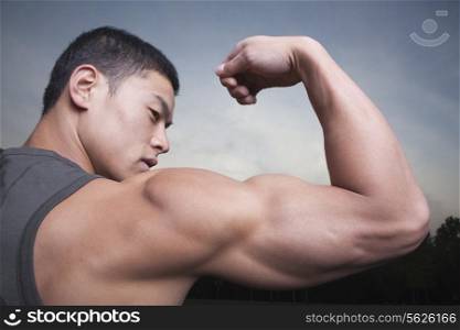 Young Man showing off his bicep muscles
