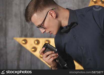 Young man singing with vintage microphone&#xA;