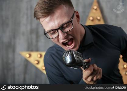 Young man singing with vintage microphone&#xA;