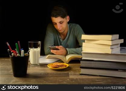 young man sitting at a study table desk with books a open sketch book and pencil bucket, university study, school.