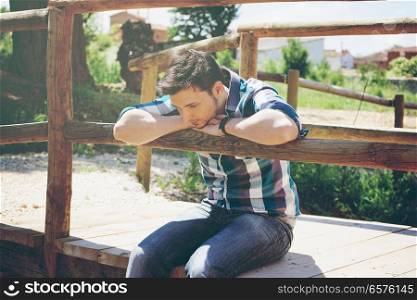 Young man sitting in a bridge