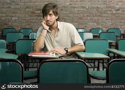 Young man sitting in a classroom and thinking