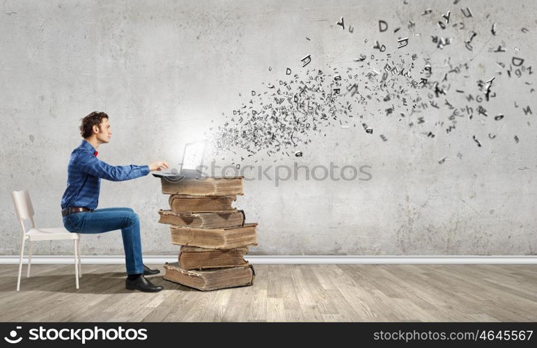 Young man sitting in chair and using laptop