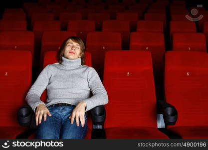 Young man sitting in cinema and watching movie