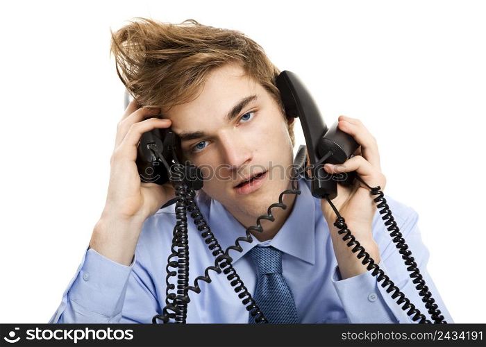 Young man sitting in the office and answering several phones at the same time