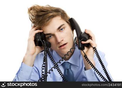 Young man sitting in the office and answering several phones at the same time