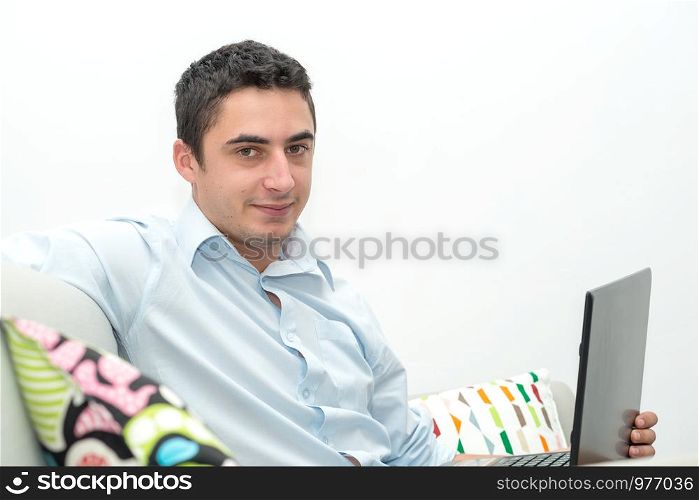 young man sitting in the sofa with a laptop