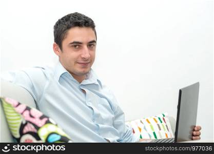 young man sitting in the sofa with a laptop