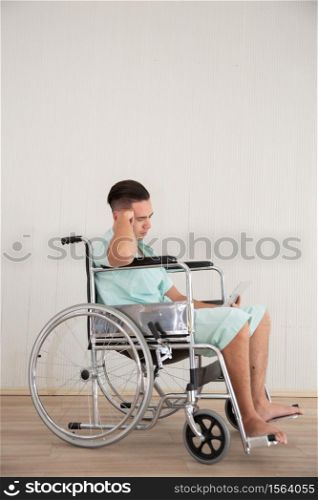 Young Man Sitting In Wheelchair At Hospital