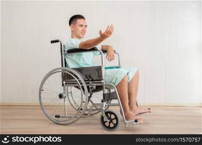 Young Man Sitting In Wheelchair At Hospital