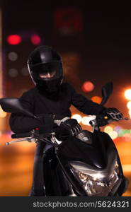 Young man sitting on his motorcycle at night in Beijing