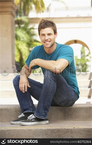 Young Man Sitting On Steps Of Building