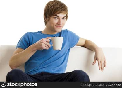 Young man sitting on the couch drinking a cup of coofee