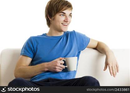 Young man sitting on the couch drinking a cup of coofee