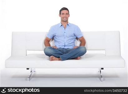 Young man sitting on white sofa