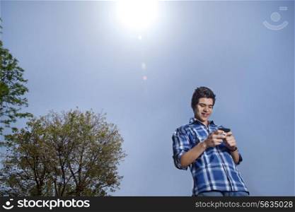 Young man smiling and text messaging
