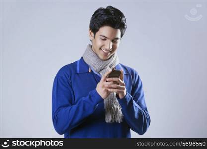 Young man smiling while reading text message