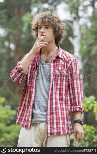 Young man smoking in forest