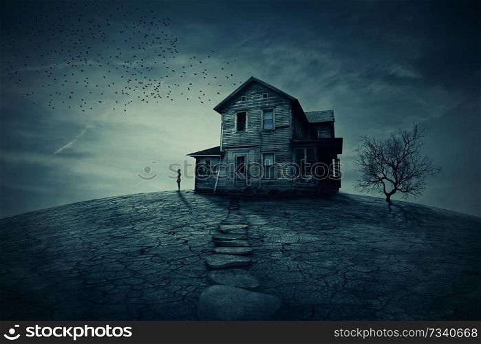 Young man stand at the corner of a ravaged house, looking far away for someone. A ghost, desolated house with a dry land and tree.