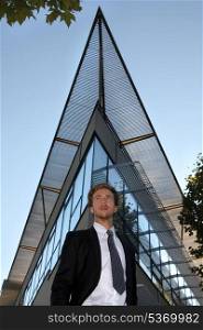 Young man standing in front of a modern building