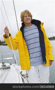 Young man standing on yacht in sea