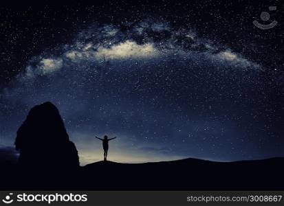 Young man standing under the stars at night. Travel concept.