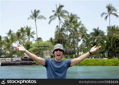 Young man standing with his arms outstretched and shouting, Captain Cook&acute;s Monument, Kealakekua Bay, Kona Coast, Big Island, Hawaii islands, USA