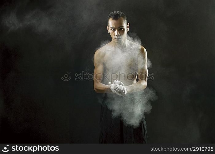 Young man standing with powder in hands