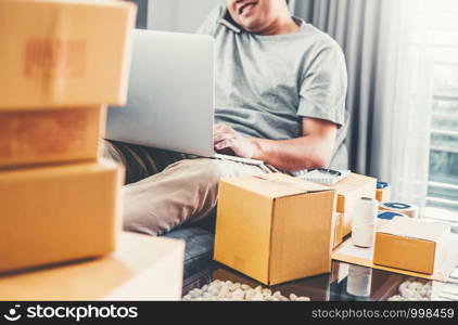 Young man startup entrepreneur small business owner Talking his Phone with customers at home,Online business seller packaging and delivery concept