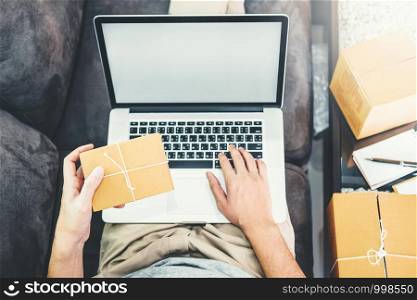 Young man startup entrepreneur small business owner working with laptop blank screen at home,Online business seller packaging and delivery concept