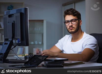 Young man staying late in office to do overtime work