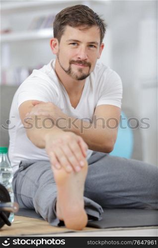young man stretching exercises at home