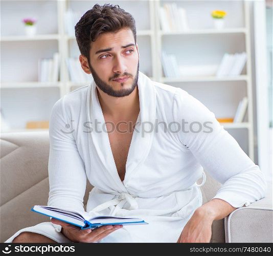 Young man student businessman reading a book studying working at home. Young man student businessman reading a book studying working at