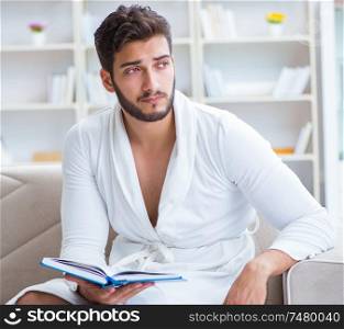 Young man student businessman reading a book studying working at home. Young man student businessman reading a book studying working at