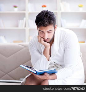 Young man student businessman reading a book studying working at home. Young man student businessman reading a book studying working at