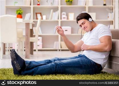 Young man student listening to music at home