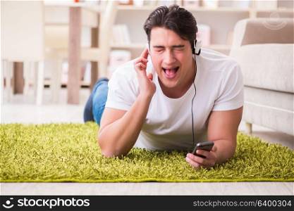 Young man student listening to music at home