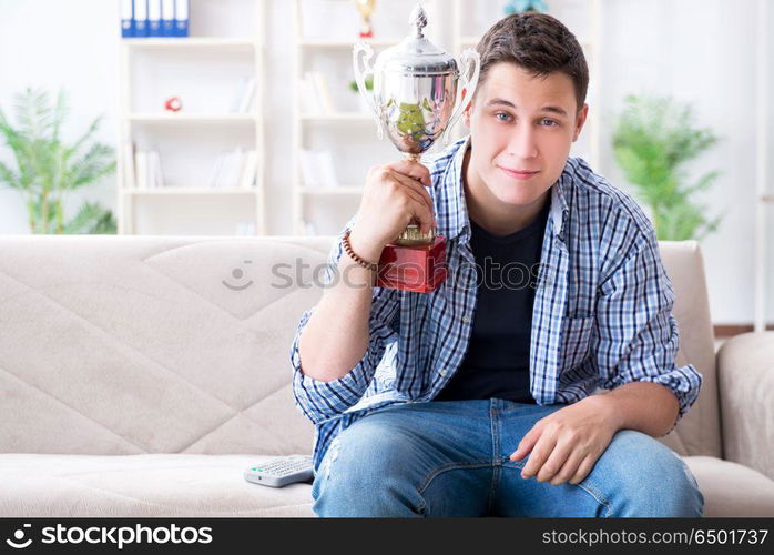 Young man student watching football at home