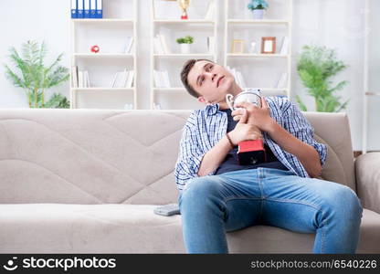 Young man student watching football at home