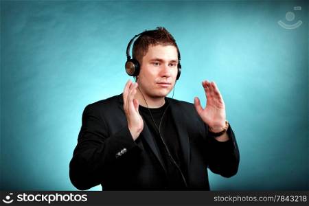 Young man student with headphones listening to music blue background