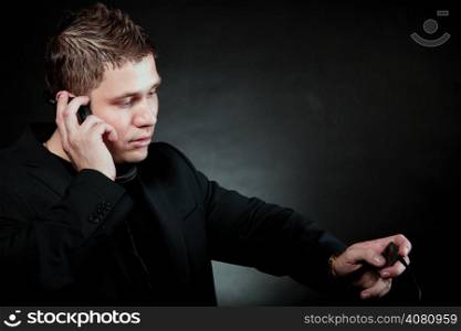 young man student with headphones use mp3 player listening to music black grunge background