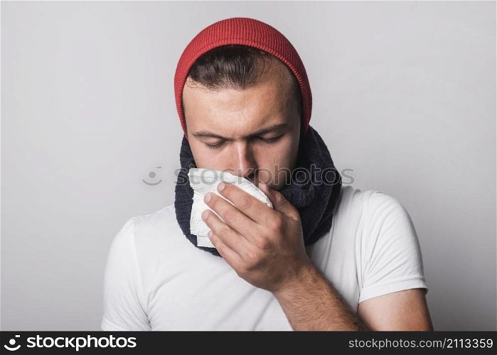 young man suffering from cold flu against gray background
