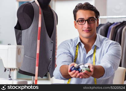 Young man tailor working on new clothing