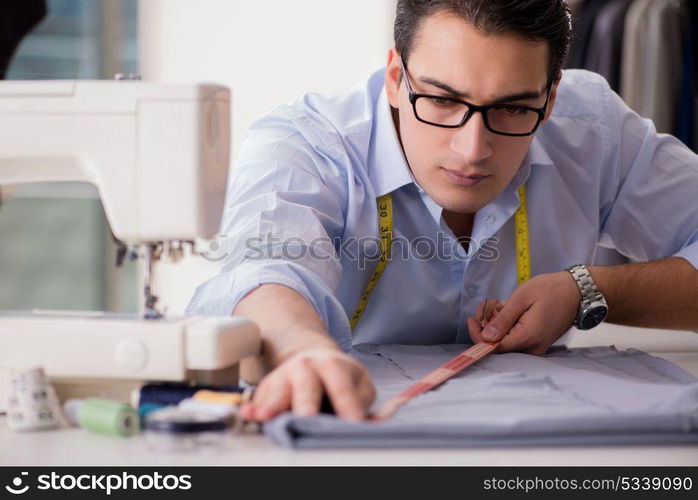 Young man tailor working on new clothing