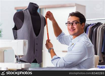 Young man tailor working on new clothing