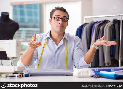 Young man tailor working on new clothing