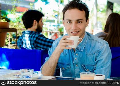 Young man taking a coffee break at coffee shop.